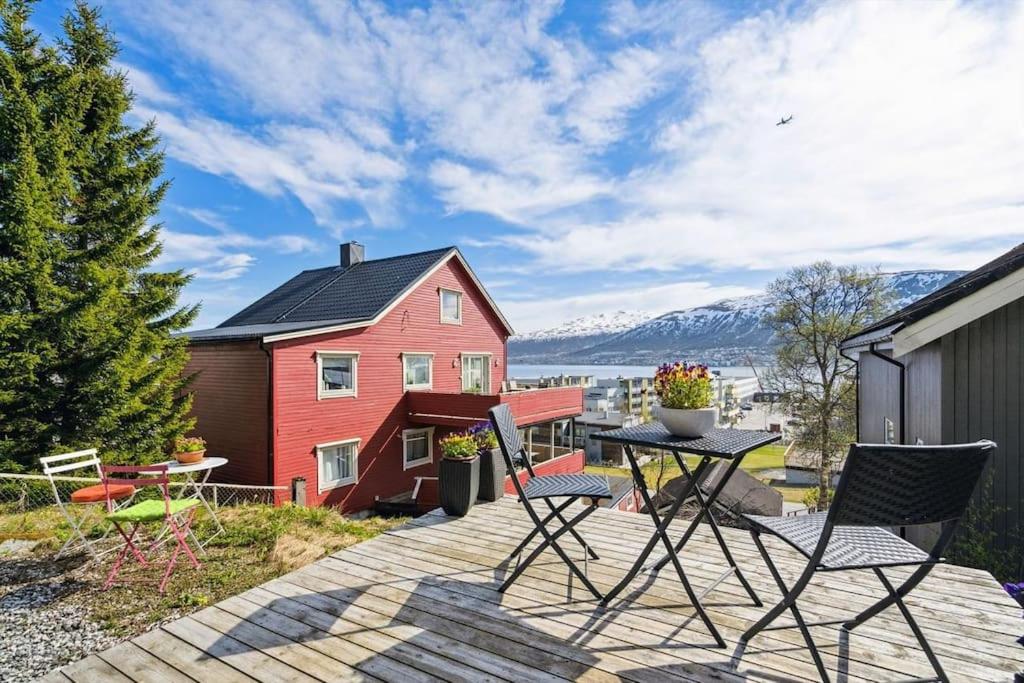 特罗姆瑟Cozy little house in Tromsø city的一个带桌椅的庭院和一座红色的房子