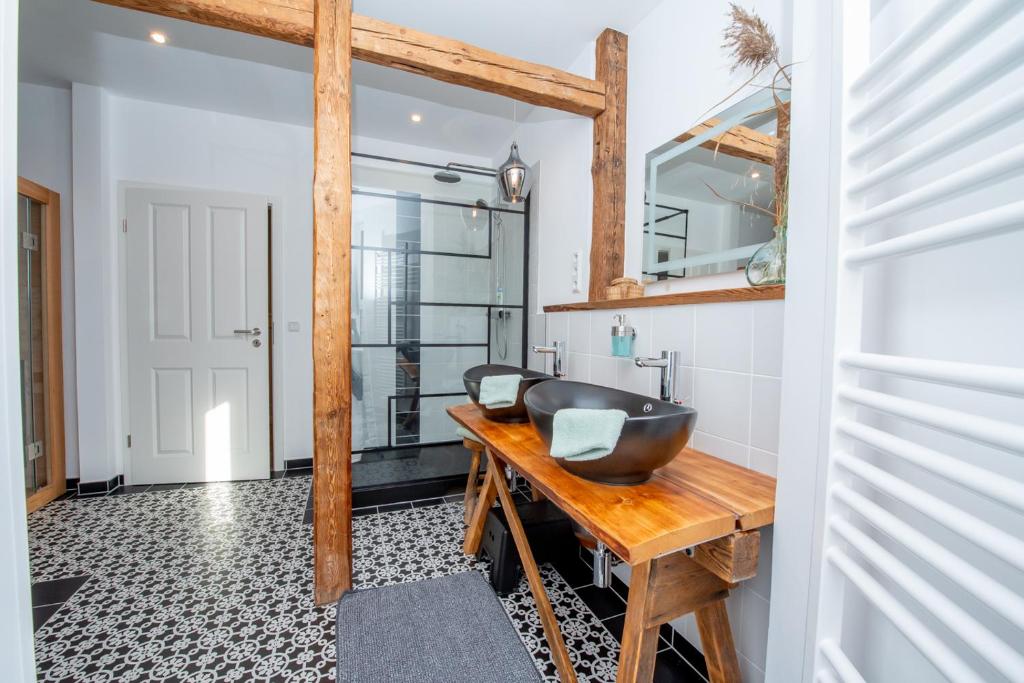 艾森纳赫Apartment Kronprinz zentral mit Infrarot-Sauna的木桌上配有黑色水槽的浴室