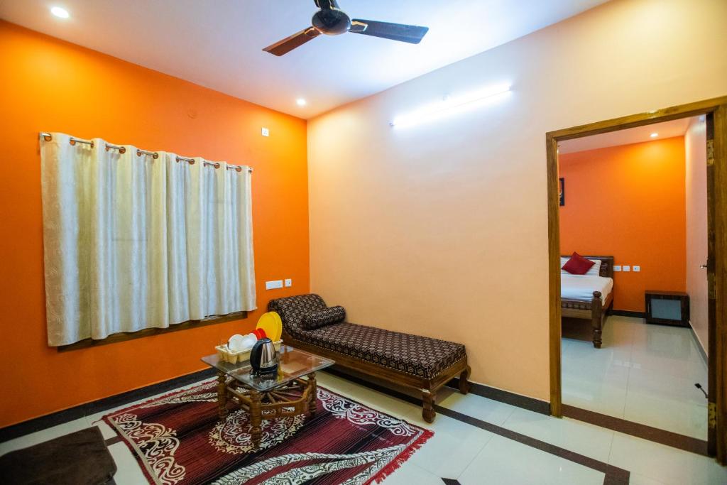 蓬蒂切里Sri Balaji Villas的客厅设有橙色墙壁、沙发和镜子