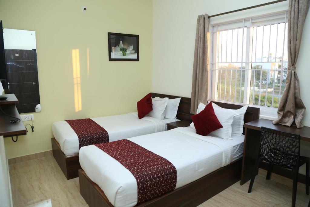 班加罗尔Bangalore Airport Inn Hotel, Near Kempegowda Airport的酒店客房设有两张床和窗户。