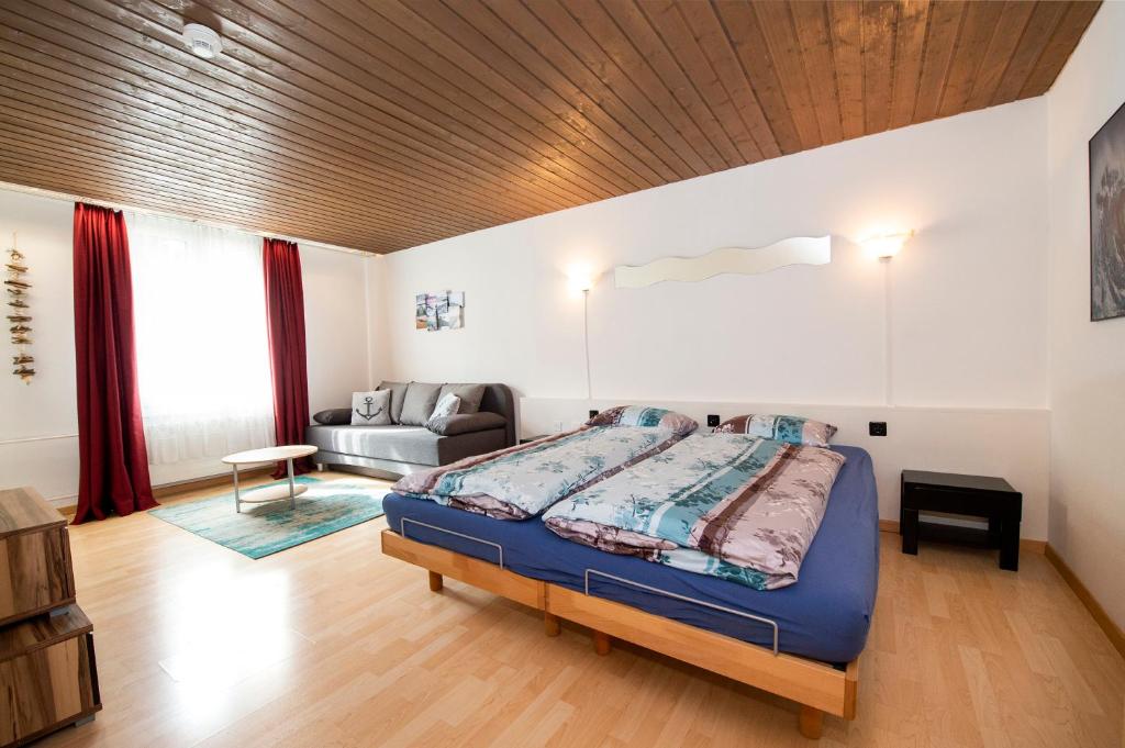 拉格斯Studio Neptun (im Zentrum von Bad Ragaz)的一间卧室配有一张特大号床和一张沙发