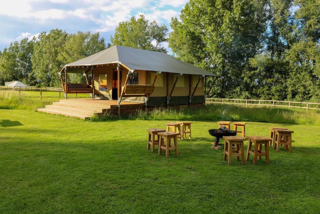 伊利Horsley Hale Farm Glamping的田野上带桌椅的帐篷