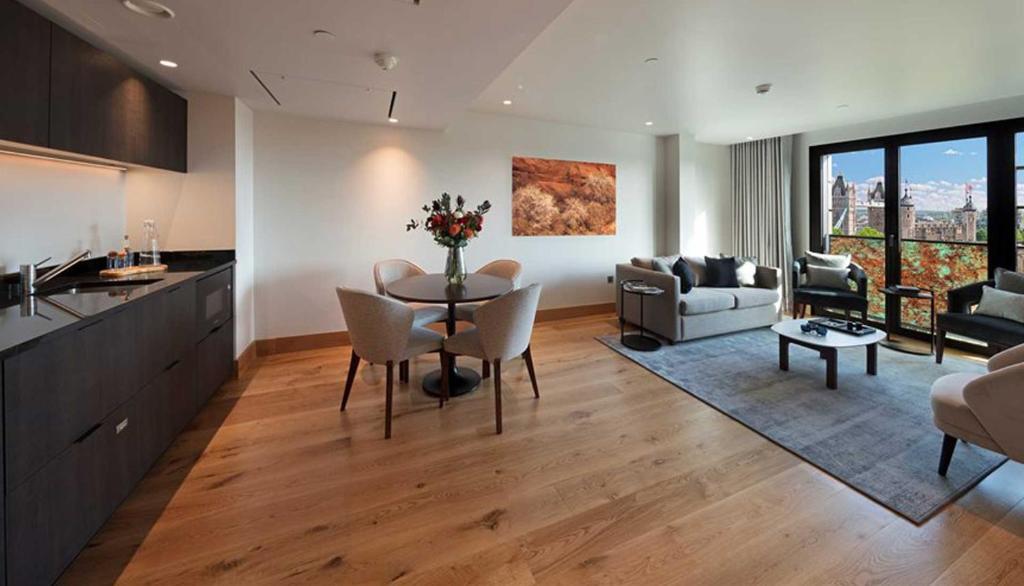 伦敦Tower Suites by Blue Orchid的厨房以及带桌椅的起居室。