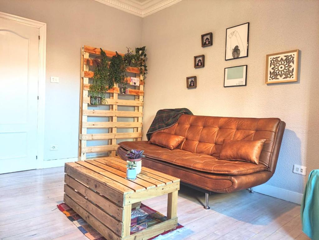 毕尔巴鄂Apartamento Mavi的客厅配有棕色皮沙发和桌子