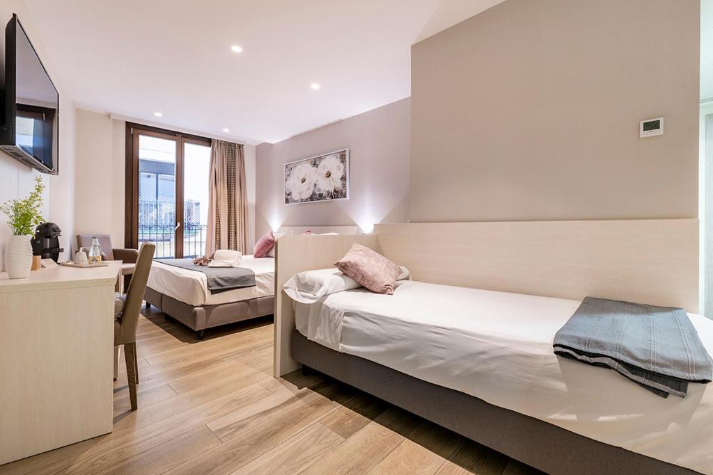 雷乌斯雷乌斯中心酒店的酒店客房设有两张床、一张桌子和一张桌子。