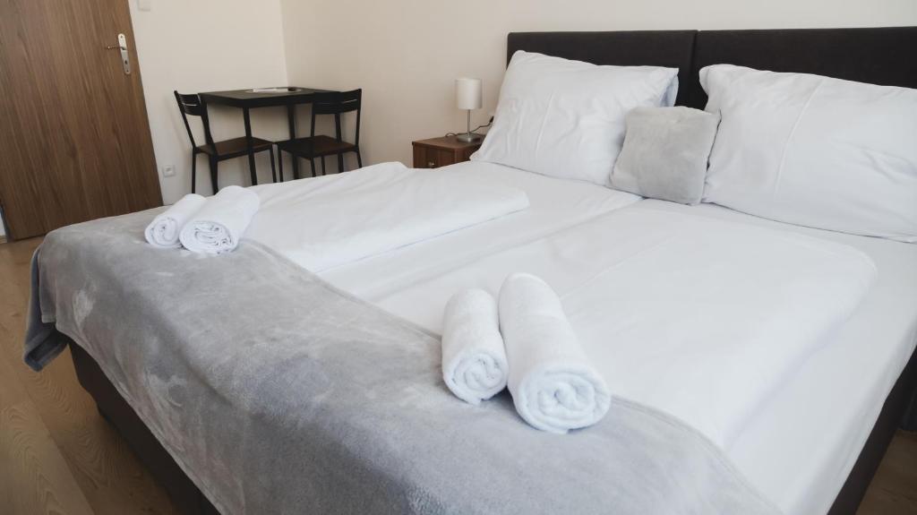 兹林Hotel U Ševce的一张白色大床,上面有3条滚毛巾