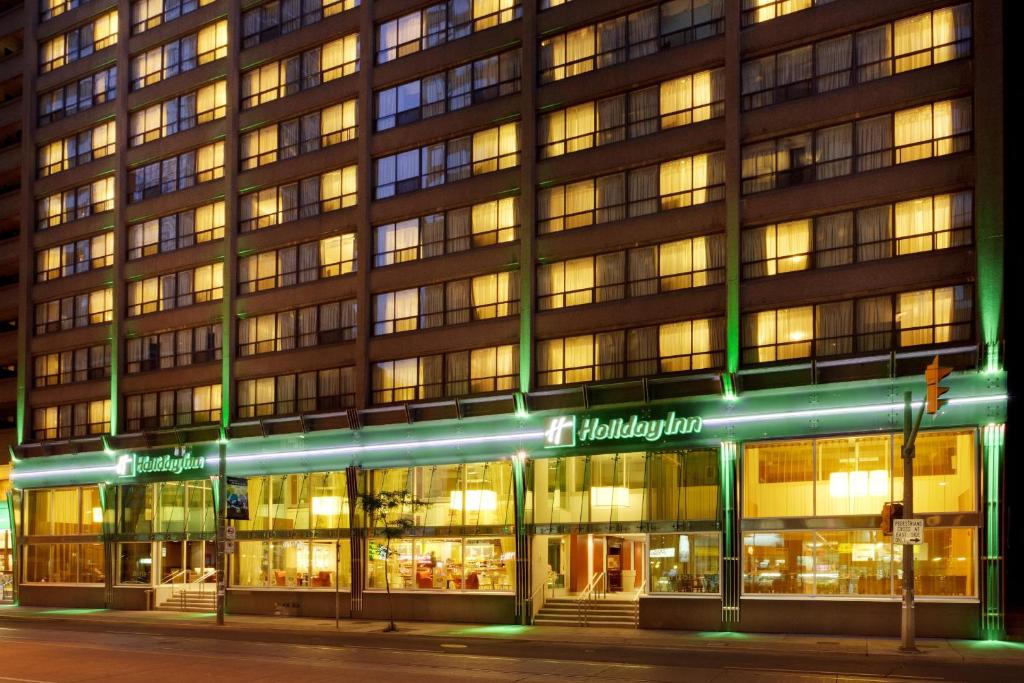 多伦多多伦多中心假日酒店的一间晚上有商店前的建筑