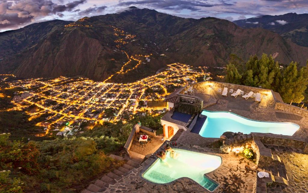 巴尼奥斯Luna Volcán, Adventure SPA的享有高山上带游泳池的别墅的空中景致