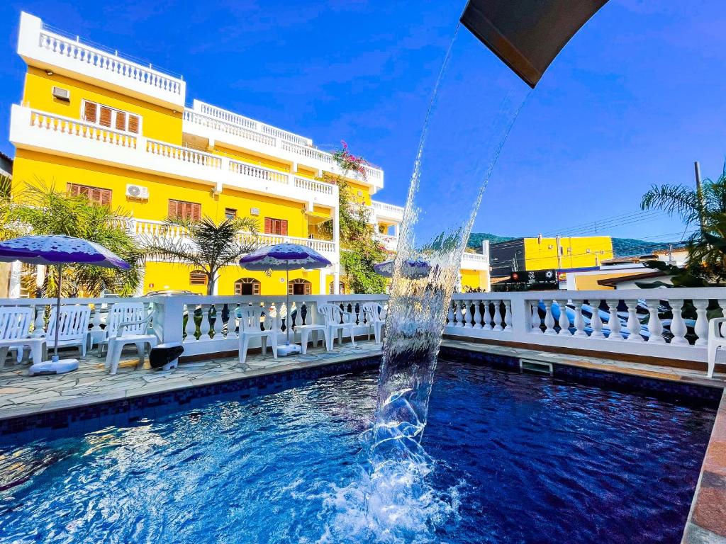 乌巴图巴大西洋公园酒店的黄色建筑前的游泳池中的喷泉