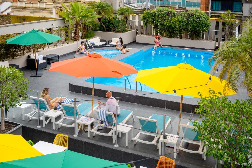 阿德莱德阿德莱德大臣酒店的享有带遮阳伞的游泳池的顶部景致