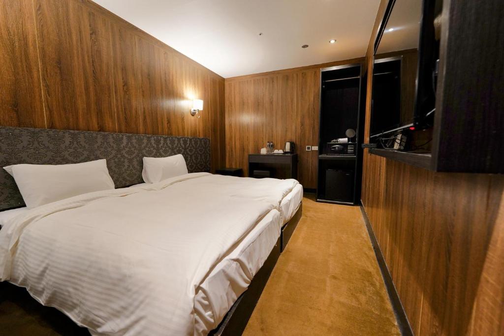 台北水滴米窝的卧室配有一张白色大床和电视。
