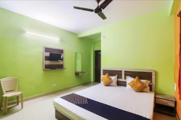 普里Sefali Dream Inn ! Puri的一间卧室设有一张床和绿色的墙壁
