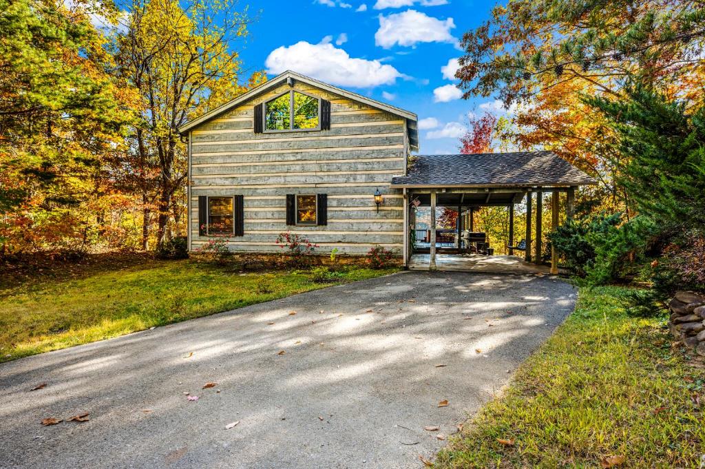 加特林堡Barenberg Cabin - Secluded Unobstructed Panoramic Smoky Mountains View with Two Master Suites, Loft Game Room, and Hot Tub的一栋前面有车道的房子