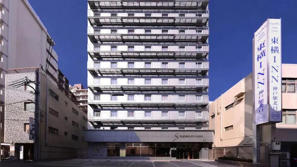 神户Toyoko Inn JR Kobe eki Kita guchi的前面有标志的高大的白色建筑