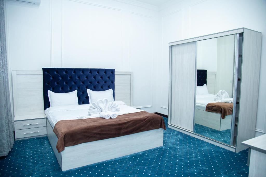 KokandLola Kokand Hotel的一间卧室配有一张大床和大镜子