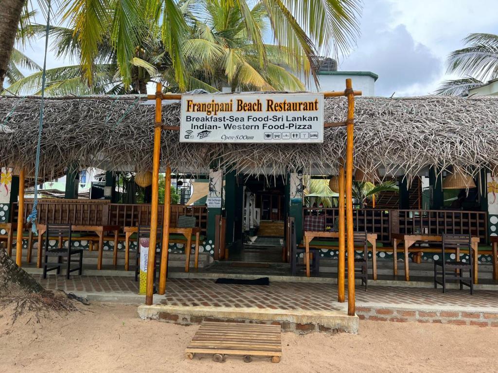 坦加拉素馨花海滩别墅酒店的海滩上餐厅前面的标志