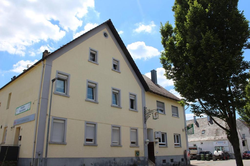 Karlsdorf-NeuthardGasthaus zum Ritter的前面有一棵树的白色大建筑