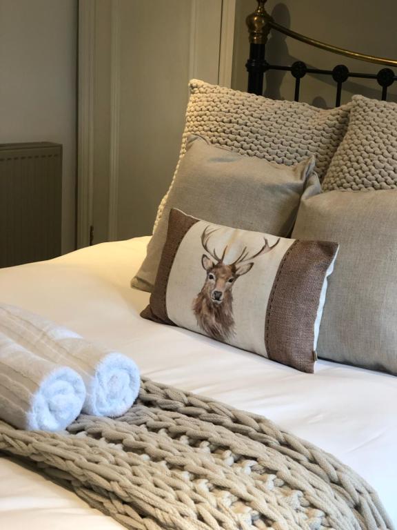 IngatestoneThe White Hart Inn的一张带枕头的床,上面有鹿的照片