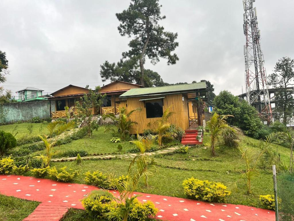 MawlyngkhungOdyssey Stays Umbir, Umiam Lake的一间位于院子中间的红地毯房子