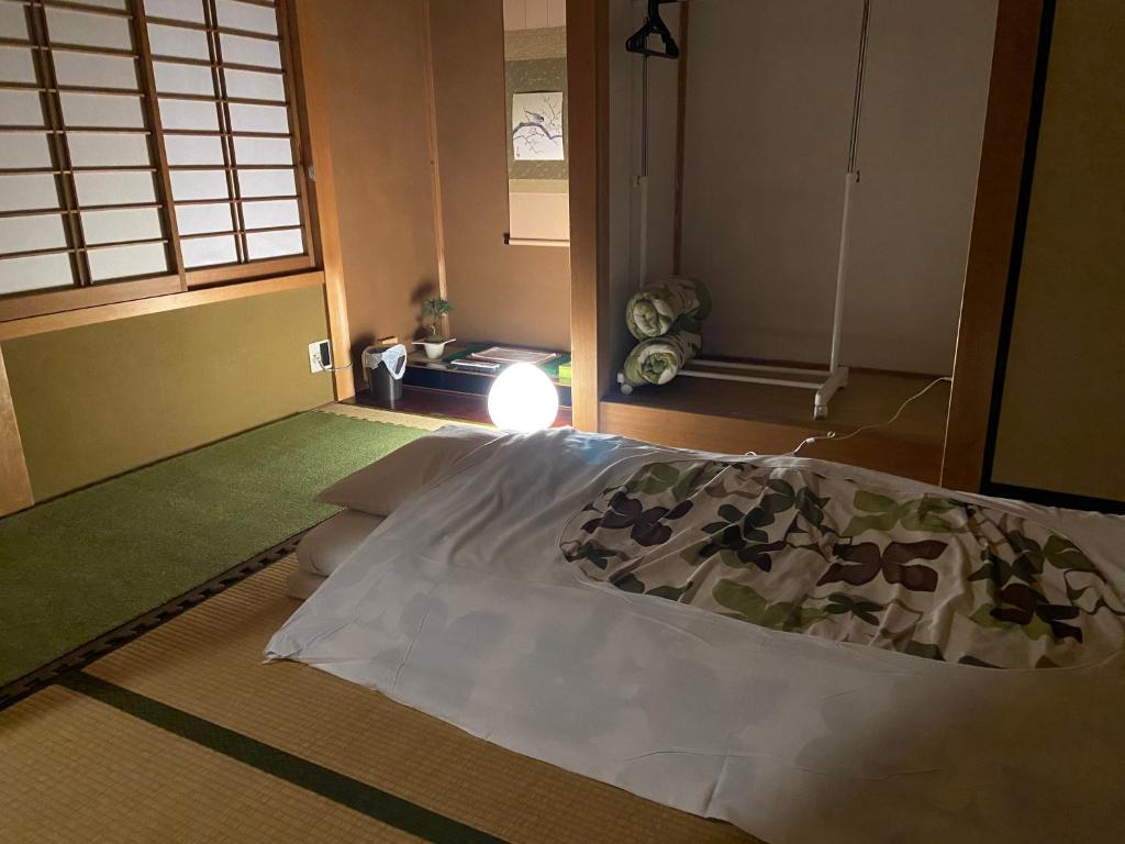 高山Takayama Ninja House的一间带床的卧室,位于带窗户的房间内