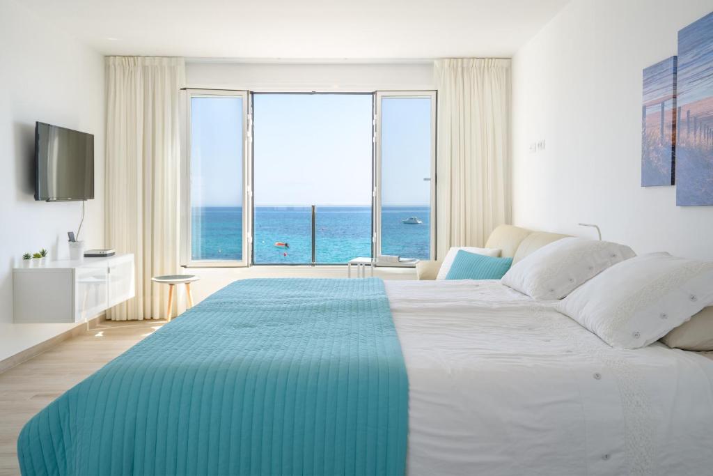蓬塔穆赫雷斯Casa Roman的一间卧室设有一张大床,享有海景