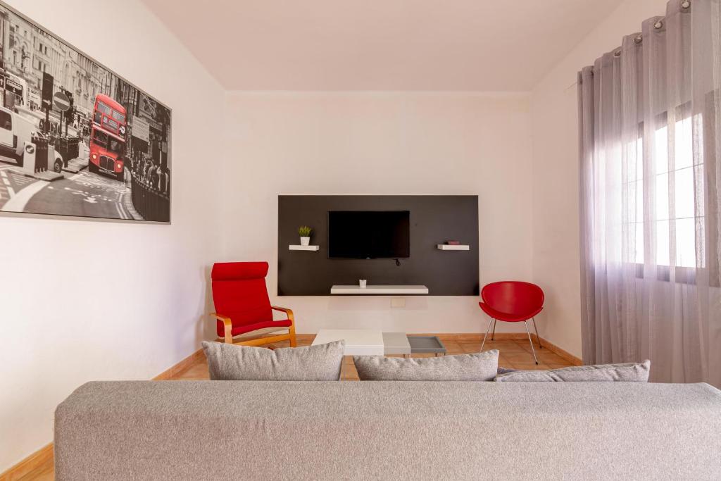 埃尔泰勒罗Los Corales的一间卧室配有一张床、一台电视和一张红色椅子