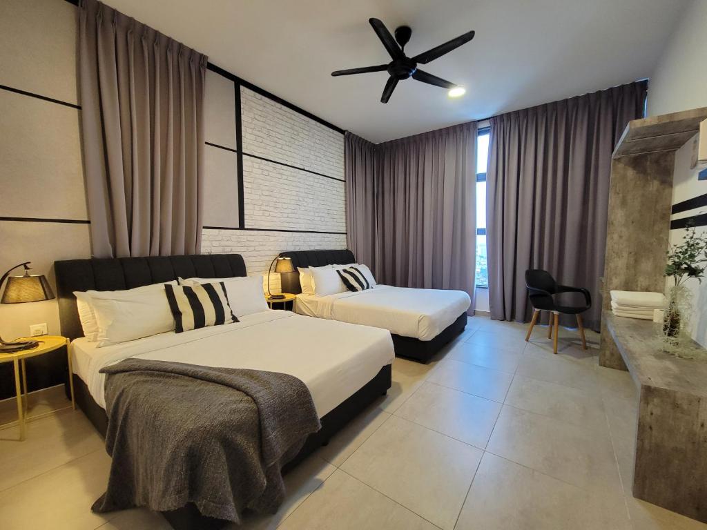 马六甲Atlantis Residences By 360 HOME的一间卧室配有两张床和吊扇