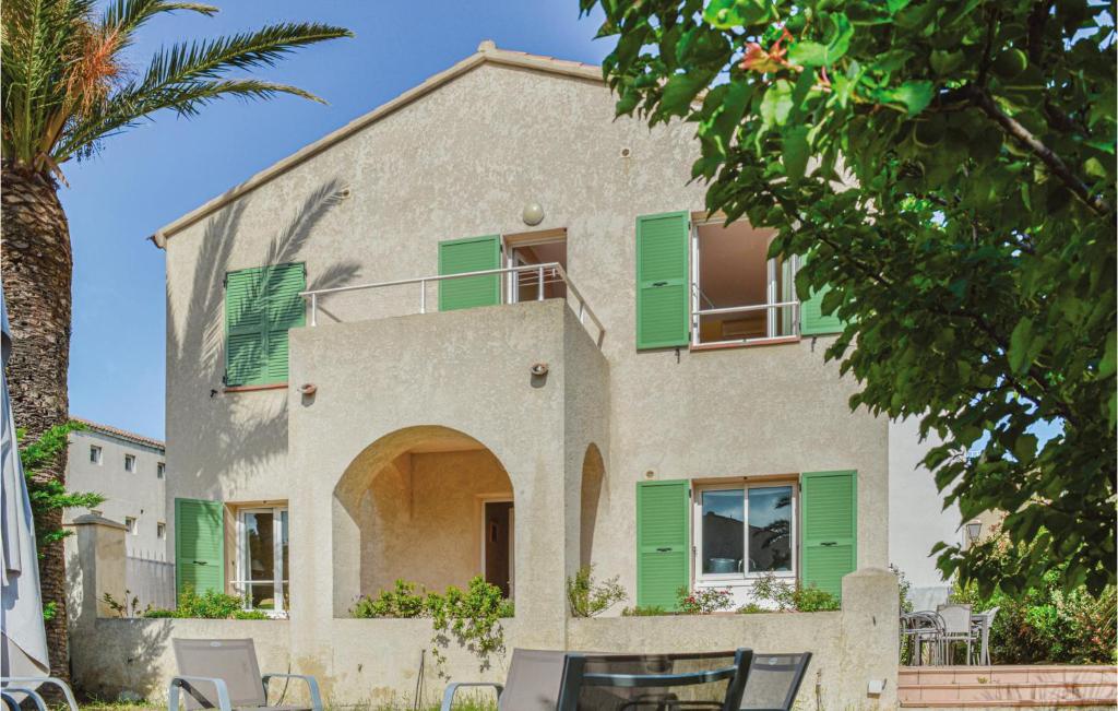 阿尔加约拉德拉海洋度假屋的一座带绿色百叶窗和棕榈树的房子