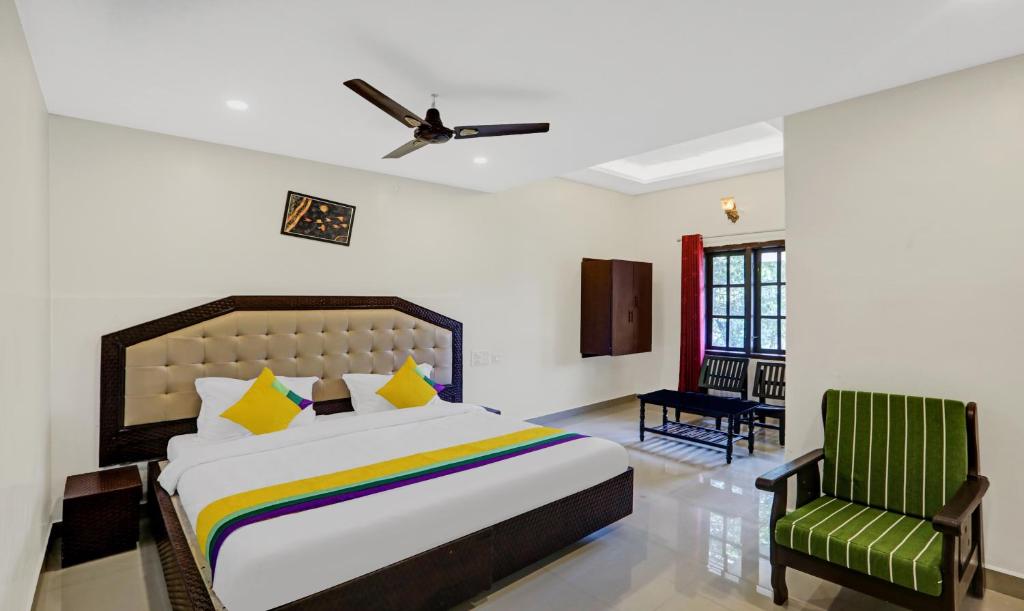 马迪凯里Itsy By Treebo - Regalia Grand 500 Mtrs From Madikeri Fort的一间卧室配有一张床和一把绿色椅子