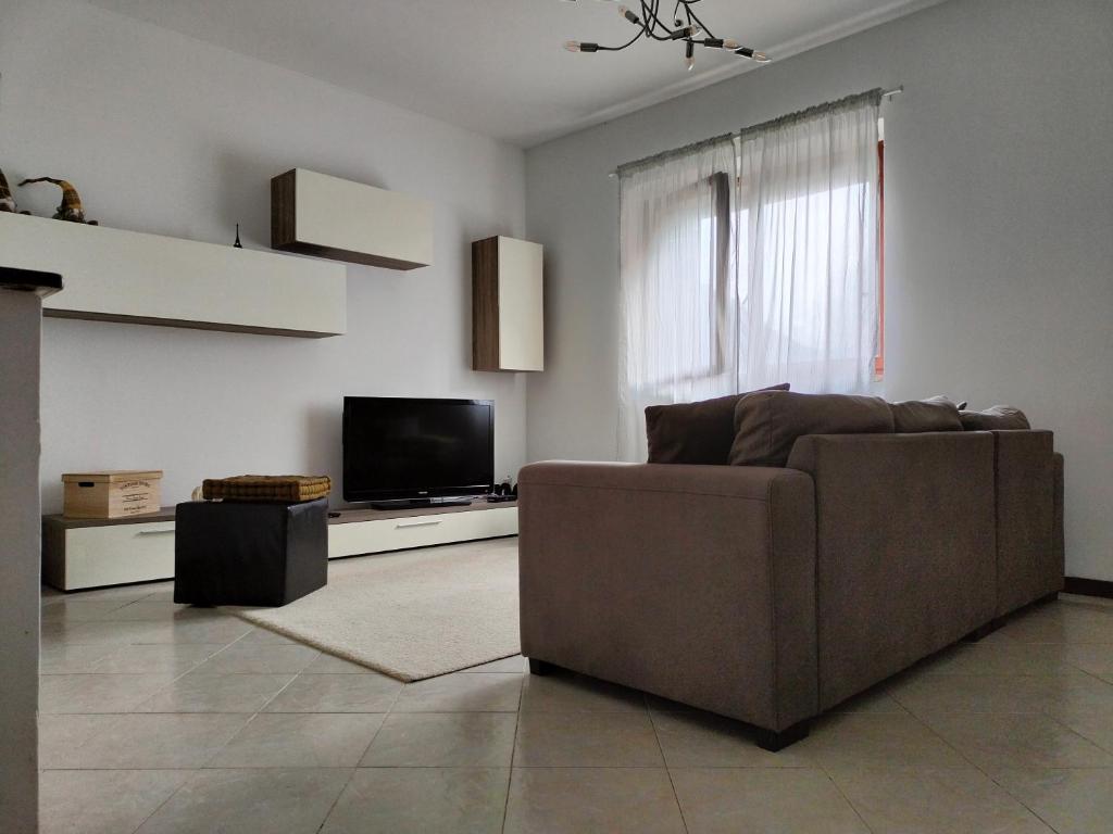 圣佩莱格里诺温泉MANZONI APARTS - SUITE Superior的客厅配有棕色沙发和电视