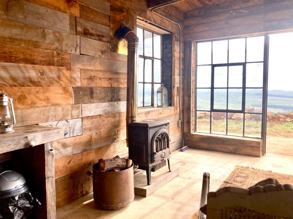 诺丁汉路Rose Mountain Cottage的小木屋内带炉灶的客厅