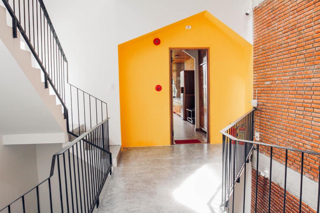 岘港Anstay Homestay & Apartment的走廊上设有楼梯和黄色的墙壁