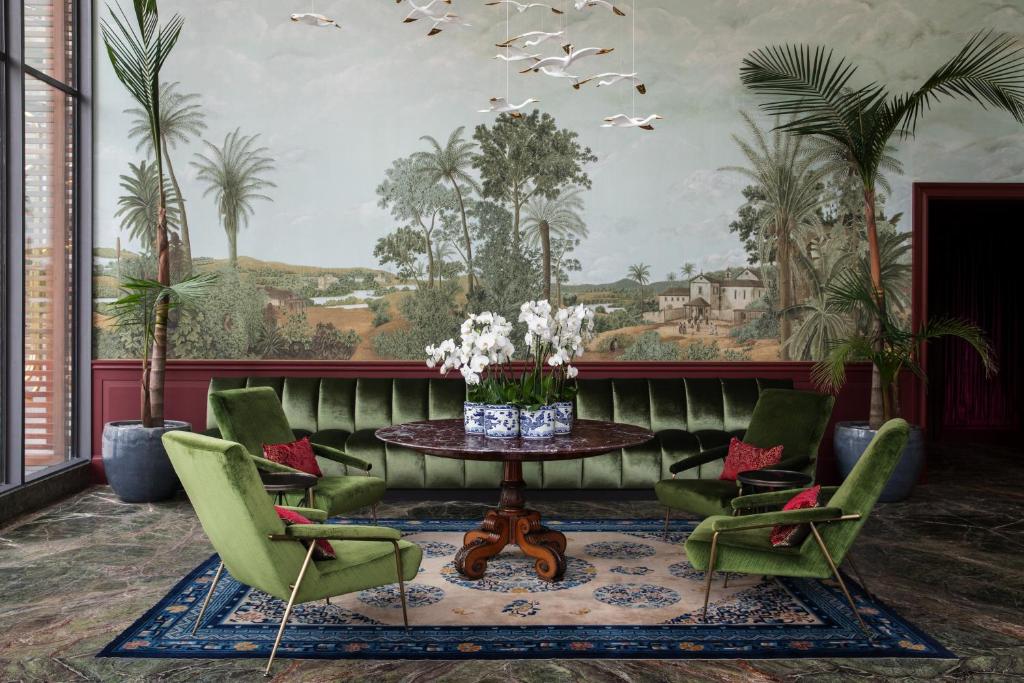 蒙得维的亚Hotel Montevideo - Leading Hotels of the World的客厅配有桌子和绿色椅子