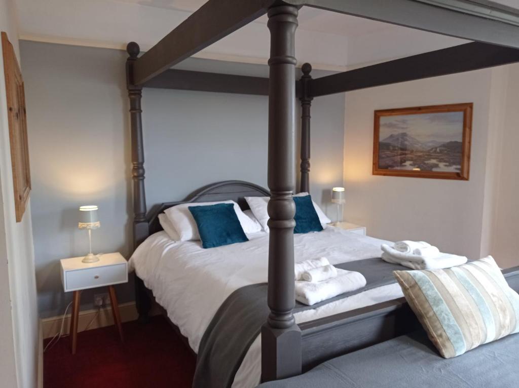海斯Castle Inn的一间卧室配有一张带蓝色枕头的四柱床