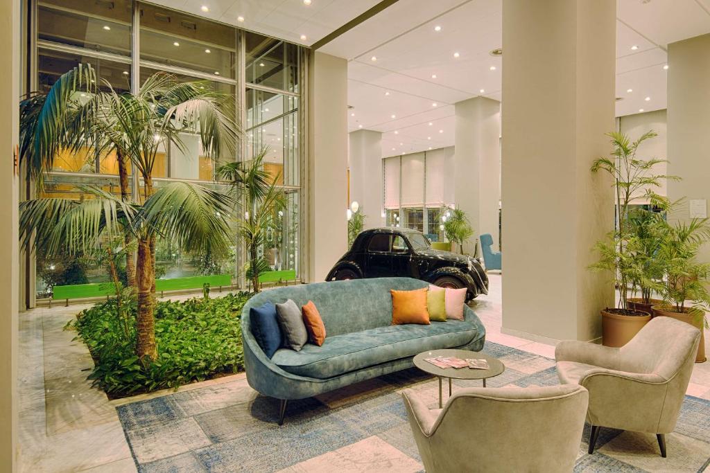 都灵灵格托都灵国会NH酒店的客厅配有蓝色的沙发和两把椅子
