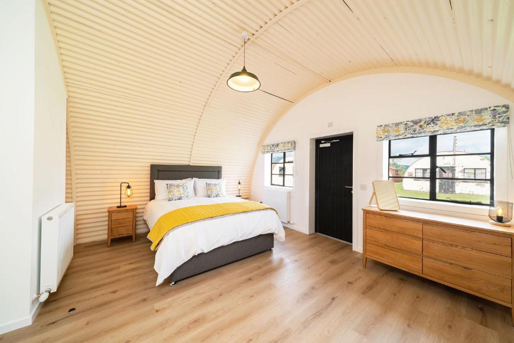 科姆里Cultybraggan Hut 35的一间卧室配有一张床、一个梳妆台和一扇窗户。