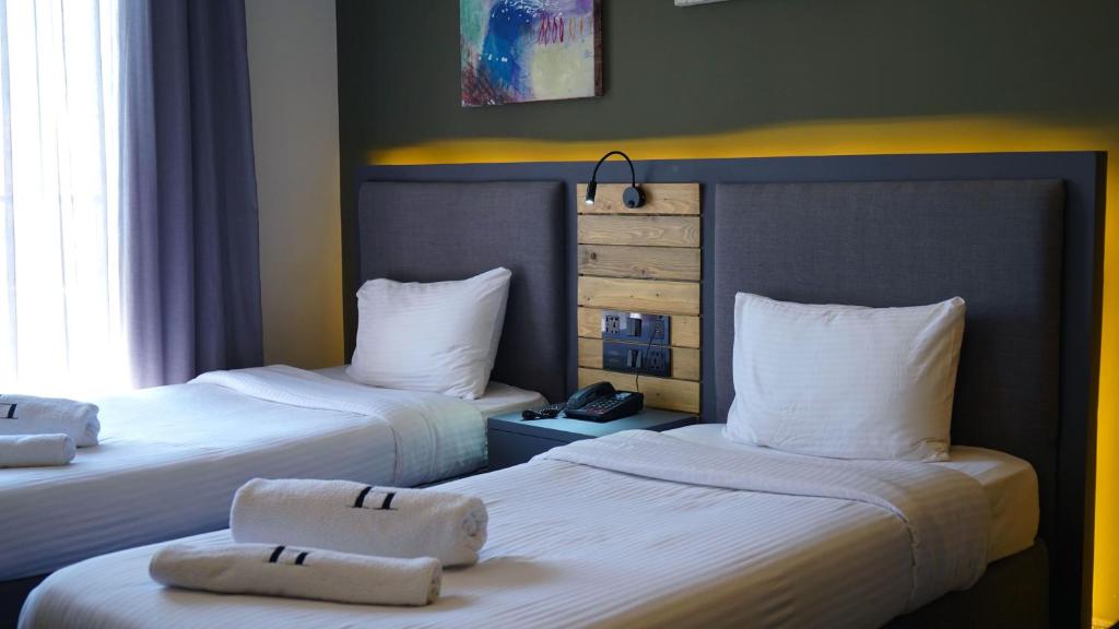 马达巴Aitch Boutique Hotel - an LIH Hotel的酒店客房,配有两张带毛巾的床