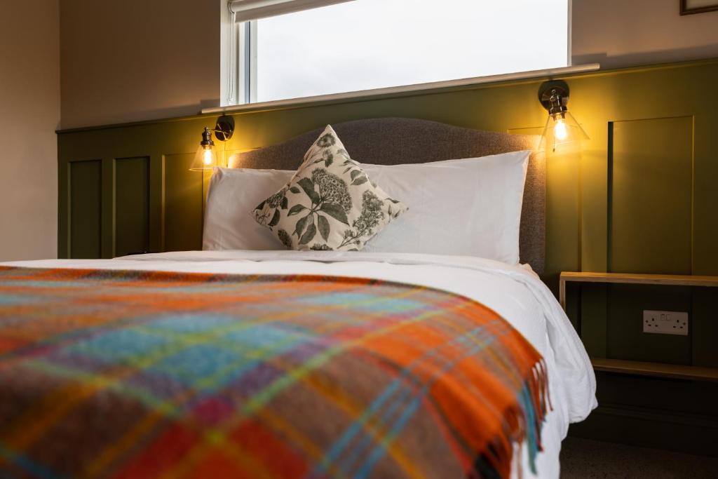 利斯坎诺Aiteall Boutique Accommodation的床上有色彩缤纷的毯子和枕头
