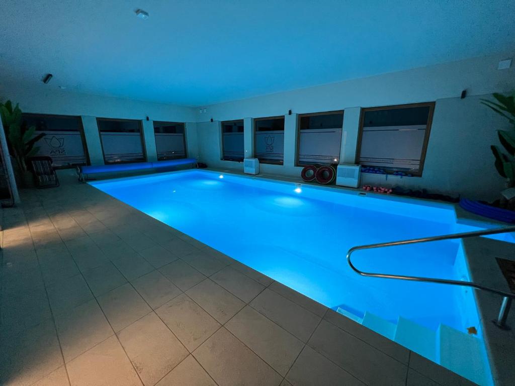 文奇察Medical Spa Kwiatowa的客房内的大型游泳池拥有蓝色的灯光