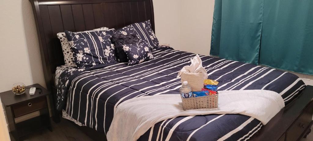 帕姆代尔Be Our Guest-Shared Home Tampa的一张带蓝白条纹棉被的床,上面有篮子