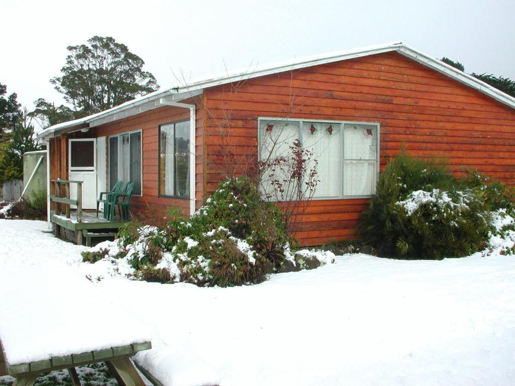 应许之地AAA级格拉纳里度假村住宿的一座小红房子,地面上积雪