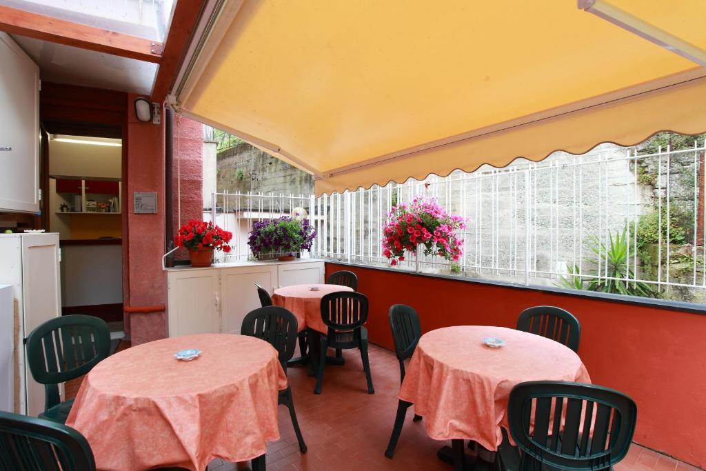 蒙特罗索阿尔马雷阿尔伯格卡鲁吉奥酒店的餐厅里摆放着两把桌子和椅子,花香