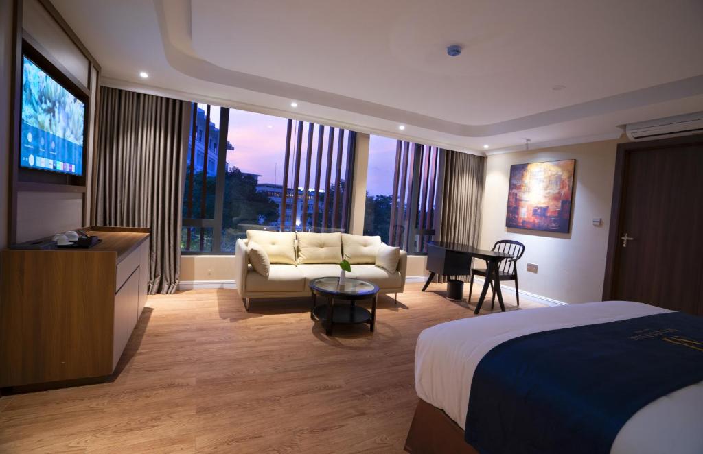 顺化Millennium Hue Hotel的酒店客房配有床、沙发和电视。