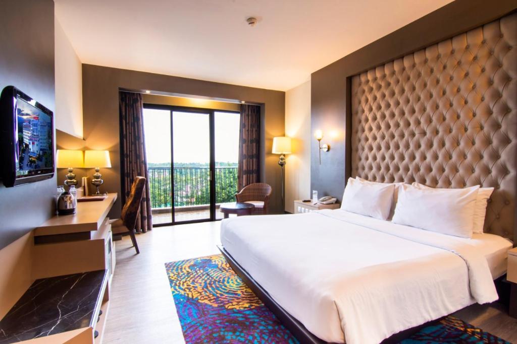 武吉丁宜武吉丁宜格兰德洛基酒店的一间酒店客房,设有一张大床和一个大窗户