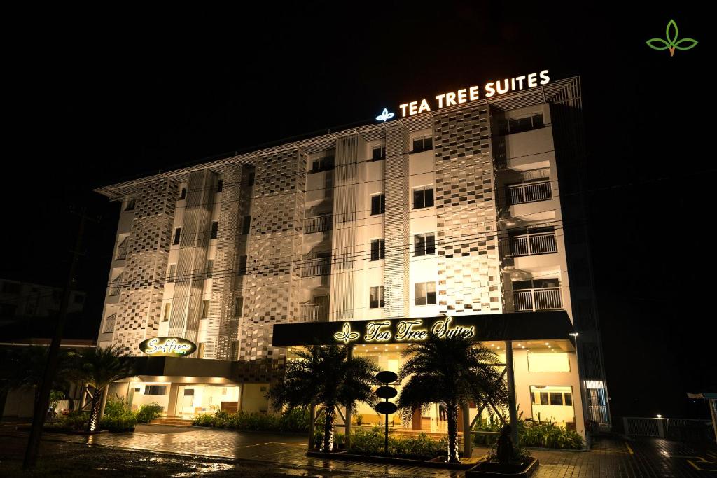 马尼帕尔Tea Tree Suites,Manipal的带有阅读茶树套房标志的酒店建筑