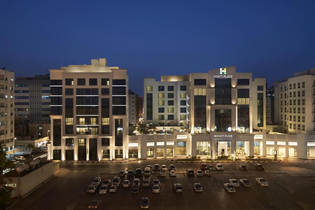 迪拜Hyatt Place Dubai Al Rigga Residences的夜间大楼前的停车场