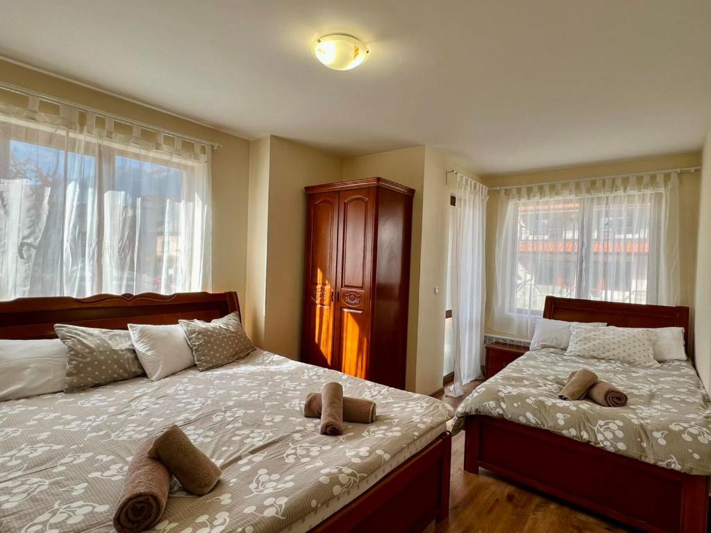 班斯科Prime Apartments的一间卧室设有两张床和两个窗户。