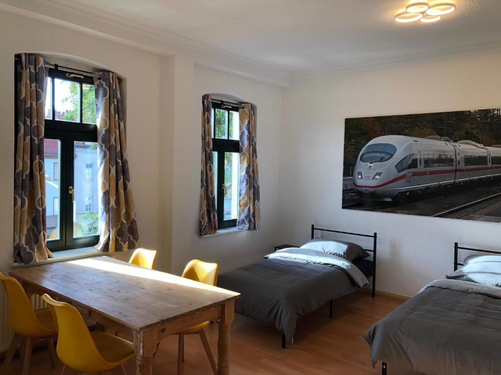 爱尔福特Ferienwohnung Nordluft的客房设有两张床、一张桌子和一张火车照片