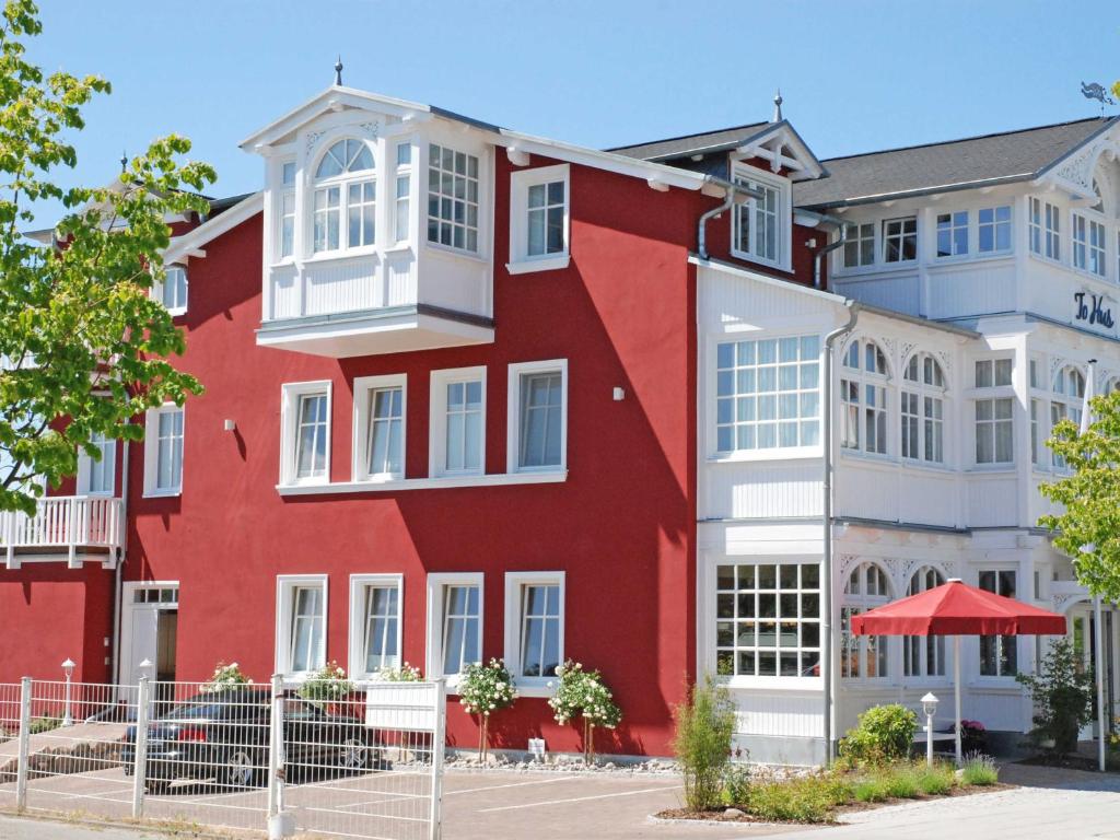 奥斯赛拜-塞林Villa "To Hus" F590 - Appartement 03 im ersten OG mit Balkon的红色的建筑,设有白色的窗户