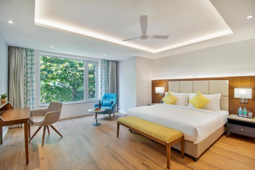 戈阿韦尔哈Aiden by best Western Vagator Goa的配有一张床、一张桌子和一张桌子的酒店客房